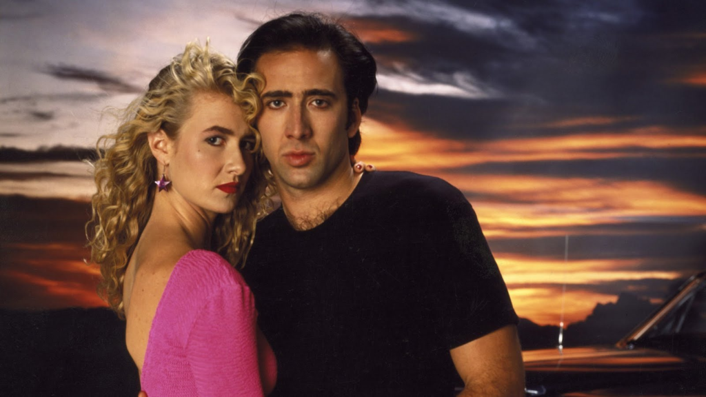 Wild at Heart sahnesi, David Lynch romantik gerilim, Lynchian aşk hikayesi, Nicolas Cage performansı, Laura Dern sahneleri, sürrealist yolculuk filmi, sinema ve özgürlük teması, sinematografik yol filmi, kült film görselleri, sinema ve tutku, David Lynch film estetiği, sıra dışı aşk hikayesi, unutulmaz film sahneleri, noir film atmosferi, sinema ve rock’n’roll, etkileyici görsel anlatım